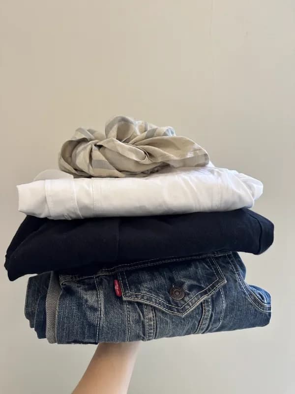 Sneakers på stabel foldet tøj hos Lidkøb secondhand